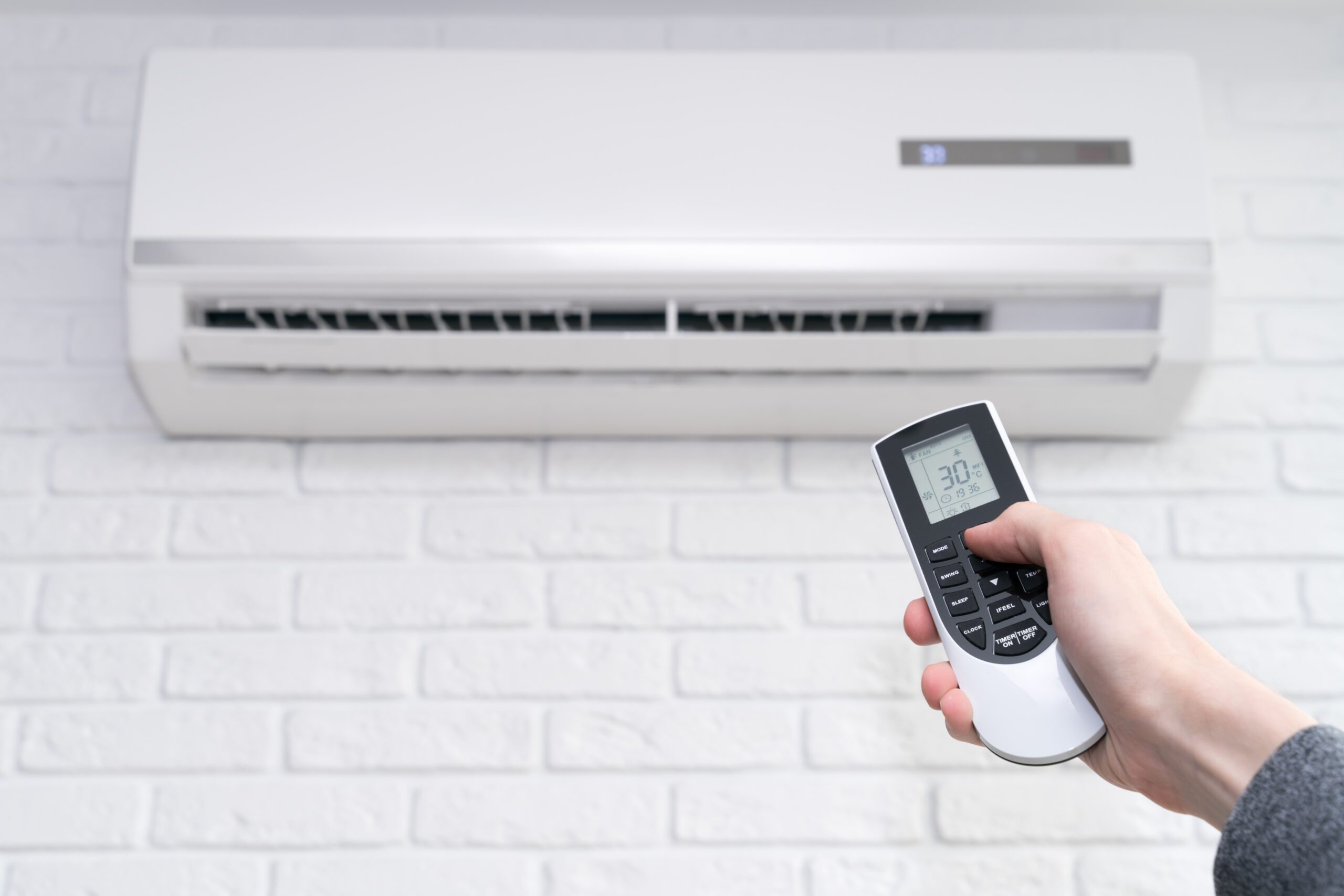home-air-conditioner-and-hand-with-remote-control-2021-08-31-17-17-56-utc